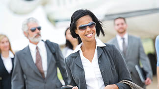 Diverse team of wealthy business executives deboarding private jet